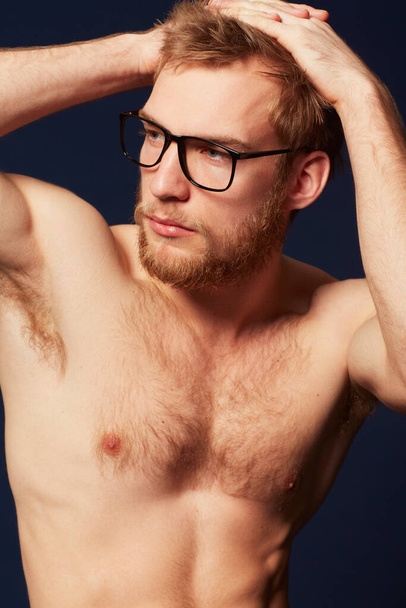 Man, shirtless with muscle and glasses in studio, confident pose and fitness, beauty and eye care on dark background. Fashion eyewear, cosmetics and skin, German model with healthy and strong body. - Photo, Image