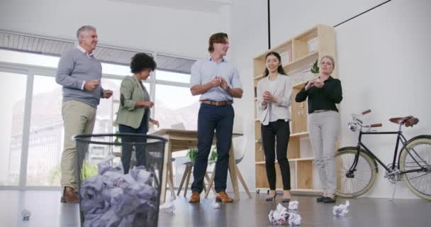 Business people, competitive and throw of paper ball in basket for relaxing on break in office. Man, woman and diverse group with game for team building, bond or relationship of employees with cheer. - Footage, Video