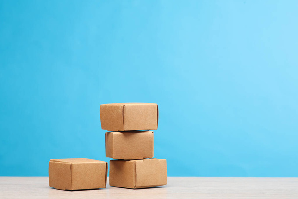Pila scatole di cartone mestiere su uno sfondo blu. Consegna, shopping, posta, trasporto, magazzinaggio - Foto, immagini