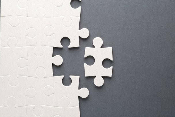 White jigsaw puzzle pieces on dark background. - Photo, Image