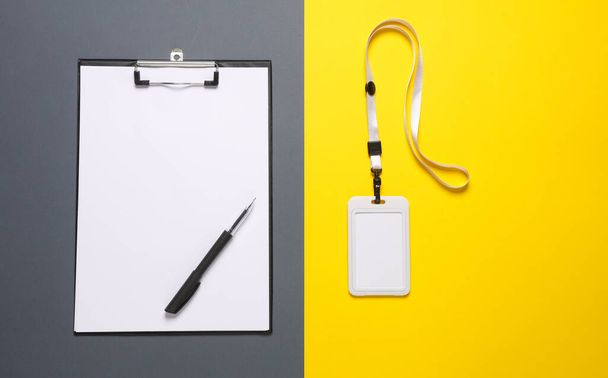 Klembord met pen en id kaart op riem, gele grijze achtergrond. Model voor ontwerp. Sociologisch onderzoek - Foto, afbeelding