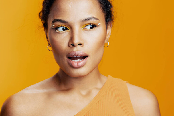 Kosmetologie Frau Mode kreativ afrikanische Haut Porträt schwarz Schönheit ethnischen Stil gelb Raum Lächeln Gesicht bunt Studio Modell Augenkopie kosmetische rosa Make-up schön - Foto, Bild