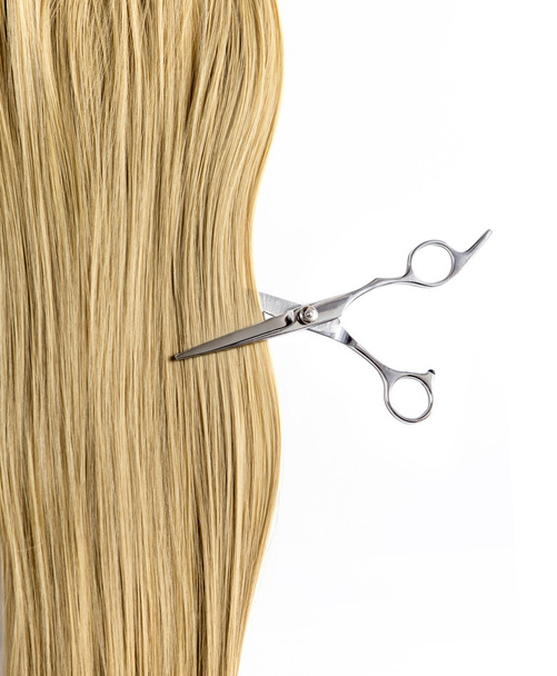 Scissors cut a lock of blond hair - Фото, зображення
