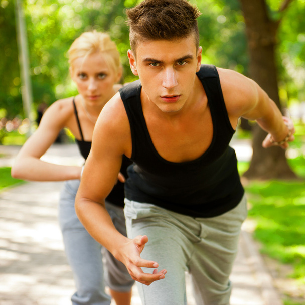 Closeup Portrait of Young Couple Jogging In Park - Foto, imagen