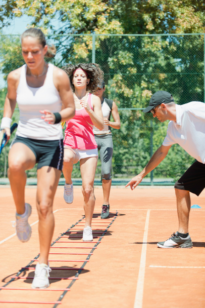 Energetic group participating in a high-energy cardio tennis training session, combining fitness and tennis skills - Photo, Image