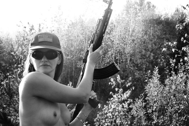 Ormanda yarı çıplak bir asker kızın siyah-beyaz fotoğrafı. - Fotoğraf, Görsel