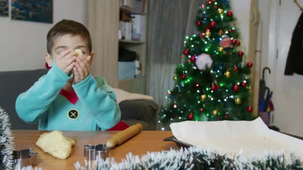Carino elfo ragazzo che fa biscotti uomo pan di zenzero davanti all'albero di Natale. Al rallentatore. Filmati 4k di alta qualità - Filmati, video