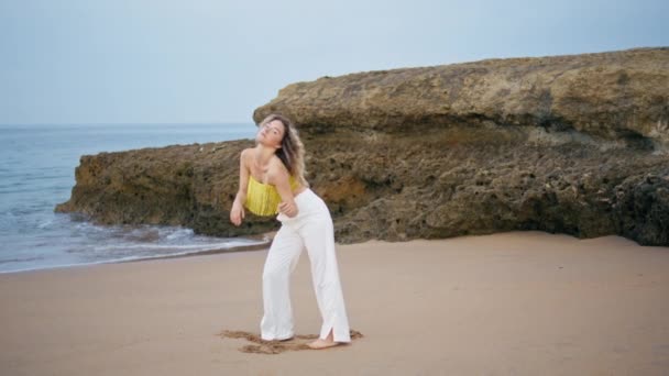 Modern performer dancing beach summer day. Flexible woman bending body to sand shore performing contemporary dance on nature. Professional girl dancer practicing freestyle making smooth movements. - Footage, Video