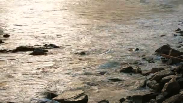 Zee golven zachtjes wassen rotsen bij zonsondergang. Slow motion. - Video