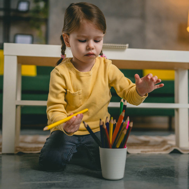Toddler girl caucasian child play with crayons at home - Photo, Image