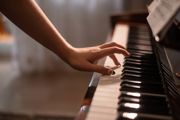 de hand van een pianist ligt op de pianotoetsen - Foto, afbeelding