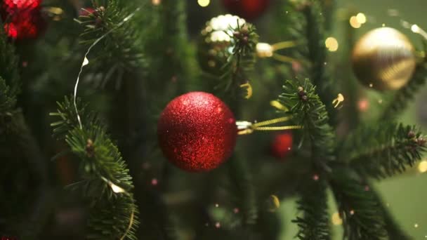Primer plano de bolas de Navidad en el árbol de Navidad. Guirnaldas Bokeh al fondo. Concepto de Año Nuevo.  - Imágenes, Vídeo