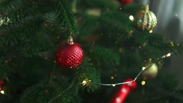 Primer plano de bolas de Navidad en el árbol de Navidad. Guirnaldas Bokeh al fondo. Concepto de Año Nuevo.  - Metraje, vídeo
