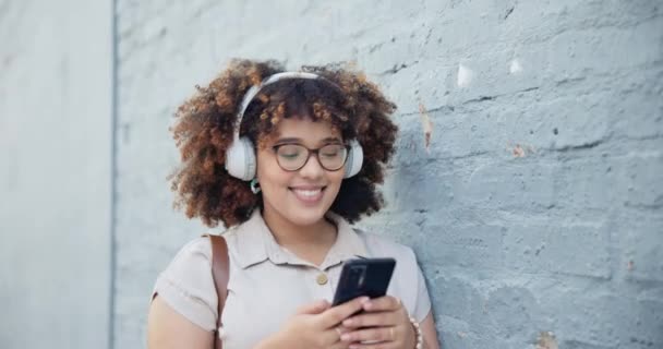 Headphones, phone or happy woman in city dancing, walking or streaming a song, music or radio. Relax, mobile or person listening to audio on online subscription in urban town for wellness or break. - Footage, Video
