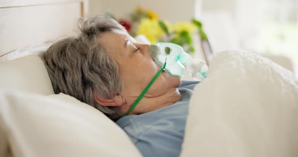 Enfermo, mujer y oxígeno para respirar en una cama de hospital, problema de salud o en coma. Medicina, sueño y un paciente mayor con una máscara para respirar para obtener ayuda médica, pulmones o ventilación en una clínica. - Metraje, vídeo