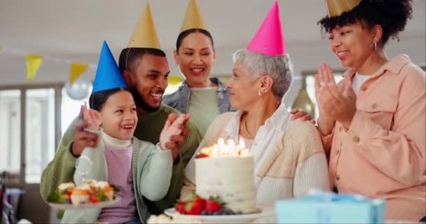 Család, gyertyafújás és boldog születésnapot a nagymamának, szerelem és ünneplés a végzős nőnek. Mosolygó emberek, idősek ölelése és megbecsülése vagy támogatása, rendezvény és party kalap vagy dekoráció. - Felvétel, videó