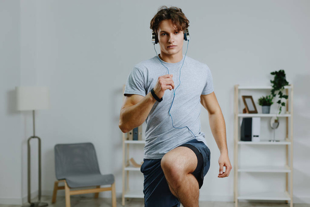 чоловіча активність навушники тренування здорові фізичні вправи спортсмен сірий стиль життя навушники йога номер спортивний будинок м'язистий спортивний внутрішній фізичний абс молодий - Фото, зображення