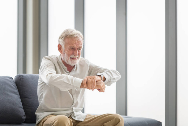 Senior man suffering from Parkinson syndrome, Man holding wrist feeling pain, Senior man holding his hand while suffering from osteoporosis - Photo, Image