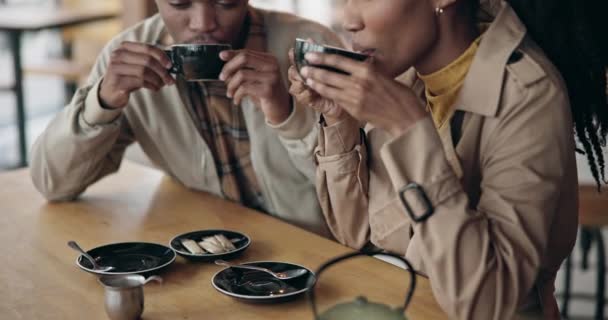 Couple, coffee and happy with conversation at cafe, restaurant or diner for bond, care or love. Black people, man and woman with tea on a weekend for break, communication and talking for quality time. - Footage, Video