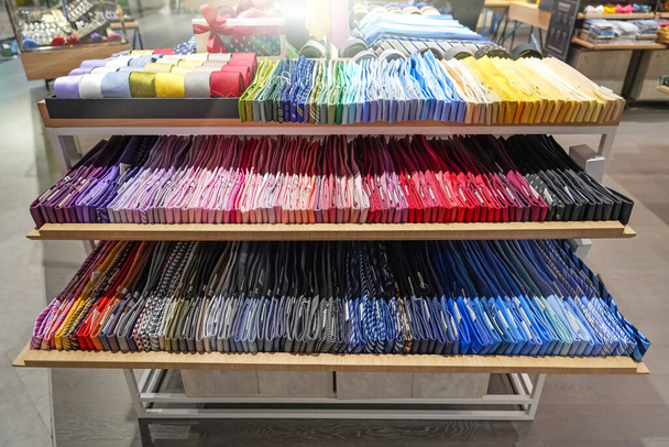 Counter με πολλά ακριβά γραβάτες διαφόρων χρωμάτων ποικιλία της επιλογής για τον αγοραστή σε τρία ράφια - Φωτογραφία, εικόνα