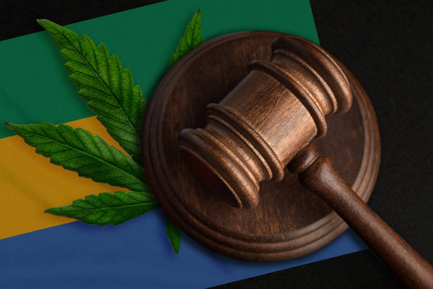 Flaga Gabonu i sprawiedliwość drewniany młotek z liściem marihuany. Nielegalny wzrost roślin konopi indyjskich i rozprzestrzenianie się narkotyków - Zdjęcie, obraz