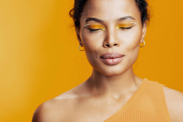 Piękna kobieta żółty piękno studio afrykański styl kosmetyczny etniczny portret twórczy czarny różowy kopia kosmetologia makijaż kolorowy uśmiech moda przestrzeń model skóra twarz - Zdjęcie, obraz