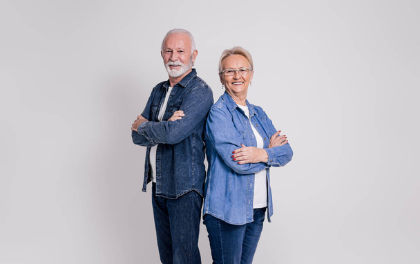 Πορτρέτο του χαμογελαστού ηλικιωμένου ζευγαριού με τα χέρια σταυρωμένα με αυτοπεποίθηση πάνω από λευκό φόντο - Φωτογραφία, εικόνα