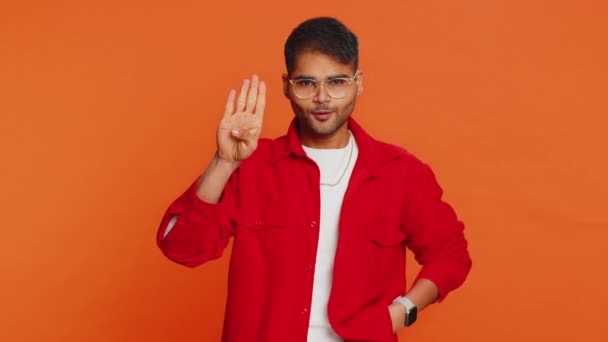 Countdown to holiday birthday celebration victory win. Indian man counting in reverse order from five to one. Arabian young guy isolated on orange background indoors. Happy New Year Merry Christmas - Footage, Video