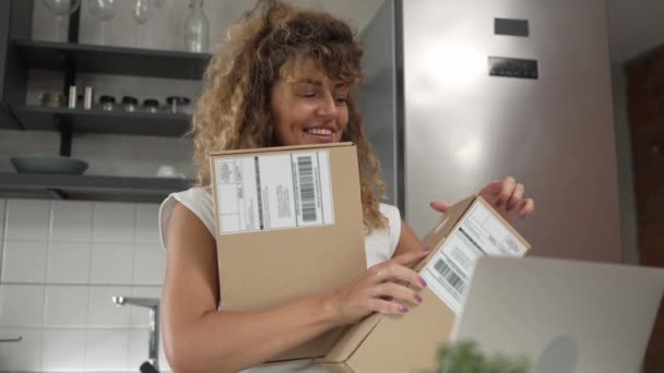 μία γυναίκα λαμβάνει και κρατά ταχυδρομικό δέμα αγόρι ταχυδρομείου ή παρόν στο σπίτι - Πλάνα, βίντεο