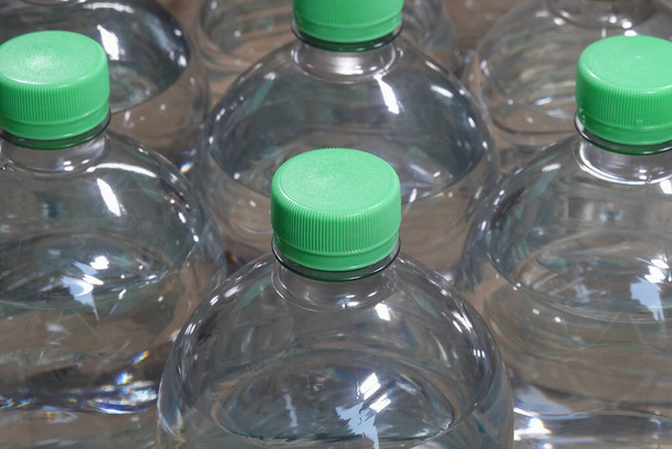 Botellas de agua de plástico con tapas verdes - Foto, imagen