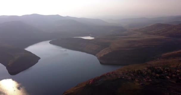 Morning, landscape and drone on lake in the mountain with sun on river, water or nature. Calm, environment and aerial view of dam with mist at sunrise in a valley or outdoor with sky and land. - Footage, Video
