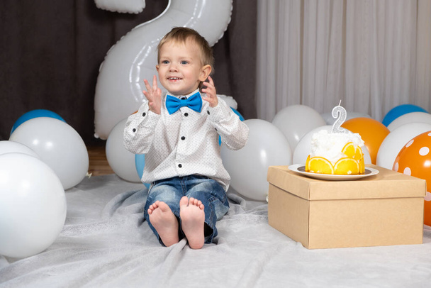 Маленький забавный мальчик хлопает в ладоши в свой день рождения - Фото, изображение
