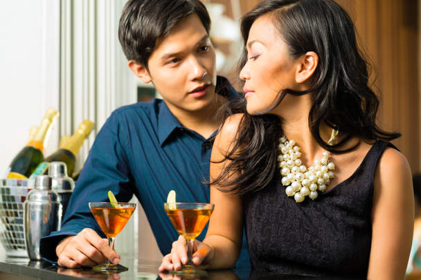 Asiático homem e mulher no bar com coquetéis
 - Foto, Imagem