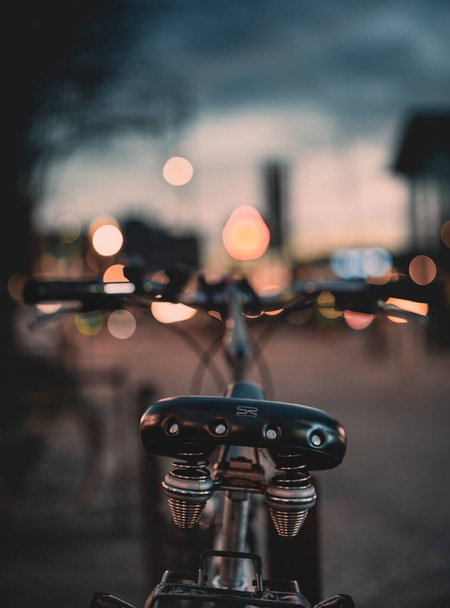 close-up de uma sela de bicicleta com luz turva da cidade no fundo - Foto, Imagem