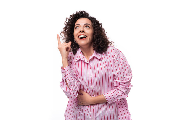 jong vertrouwen brunette krullend zakenvrouw gekleed in een gestreept roze shirt. - Foto, afbeelding
