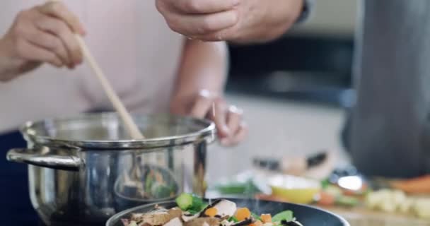 Hands of couple, cooking in kitchen with lemon, ingredients and healthy food in pan for nutrition, marriage and diet. Vegetables in pot, hand of man helping woman with meal prep and dinner in home - Footage, Video