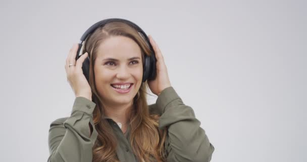 Headphones, happy and woman with music in studio dance and listening to audio, radio and song playlist. Smile, chill and person relax for online streaming, subscription and sound on gray background. - Footage, Video