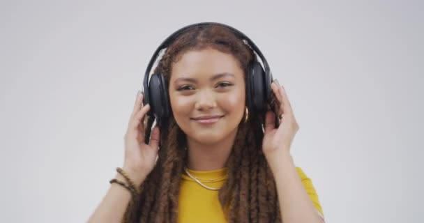Dance, headphones and face of woman in studio listening to audio, streaming song and radio. Happy, dancing and portrait of person relax with music for energy, subscription and fun on gray background. - Footage, Video