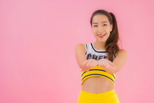 Ritratto bella giovane donna asiatica cheerleader su sfondo rosa isolato - Foto, immagini