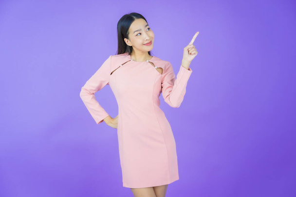 Portrét krásná mladá asijská žena úsměv s akcí na barevném pozadí - Fotografie, Obrázek