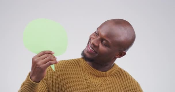 Man, speech bubble poster and confused for language, translation and social media with FAQ or questions in studio. Face of African person with chat, forum mockup and choice on a white background. - Footage, Video