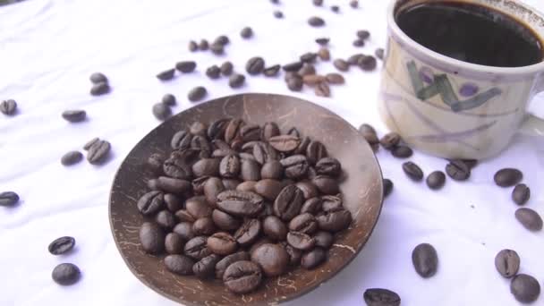 šálek kávy a kávových zrn izolované na bílém - Záběry, video
