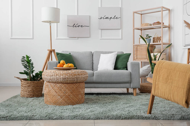 Интерьер стильной гостиной с плетеным столом и диваном - Фото, изображение