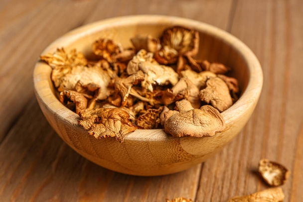 Bowl with tasty dried mushrooms on wooden background - Photo, Image