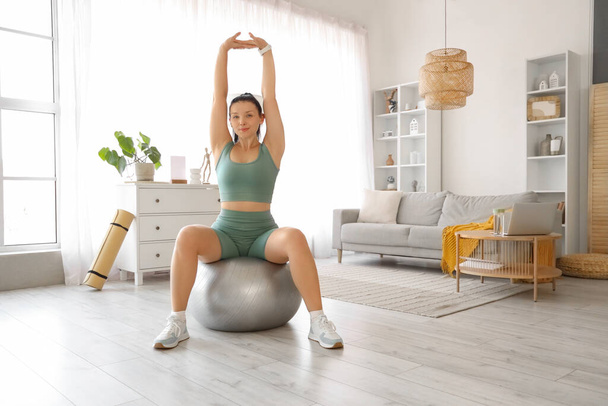 Sporty young woman training on fitball at home - Photo, Image