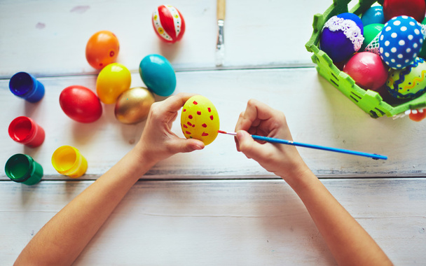 Дитячі руки малюють великодні яйця
 - Фото, зображення