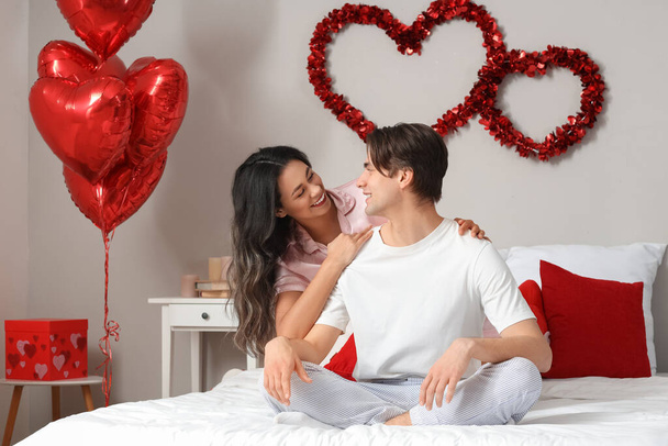 Молода пара обнімається у спальні в День святого Валентина. - Фото, зображення