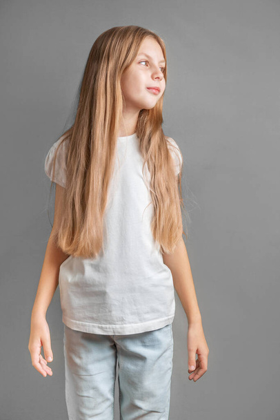 Retrato de niña linda con pelo largo y ligero en camiseta blanca - Foto, imagen
