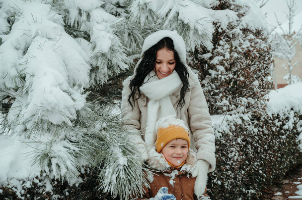 Šťastné legrační maminky s chlapcem dítě syn hrát v parku ve sněhu - Fotografie, Obrázek