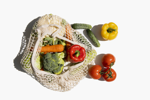 Frisches Gemüse in einer Tüte auf weißem Hintergrund. Draufsicht, flache Lage. - Foto, Bild